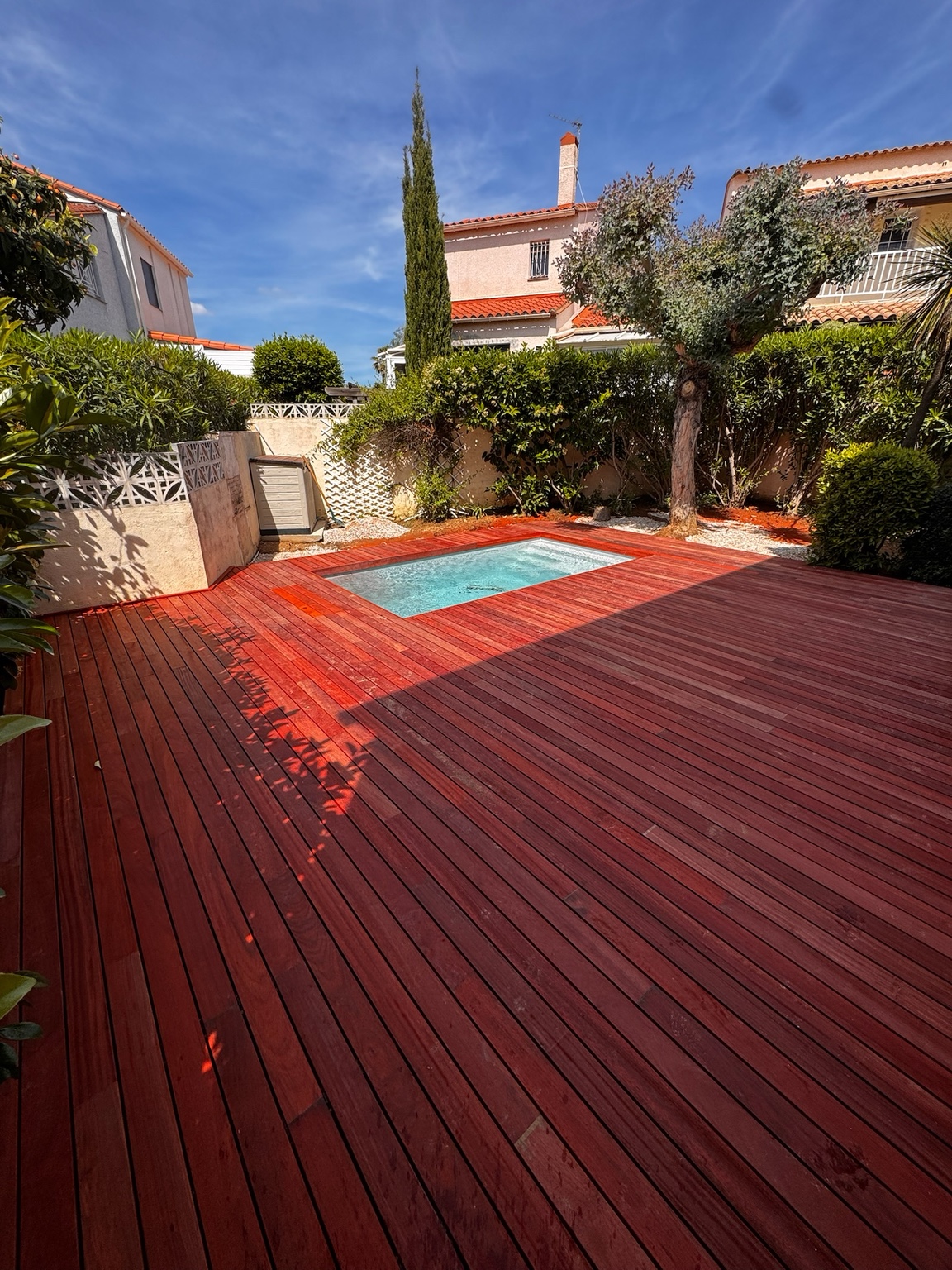 Aménagement d’une petite piscine entourée de bois rouge