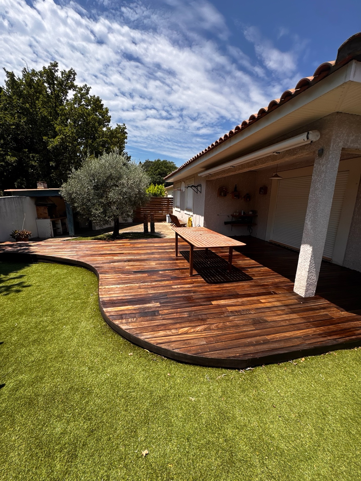 Terrasse en bois aux lignes arrondies dans un jardin